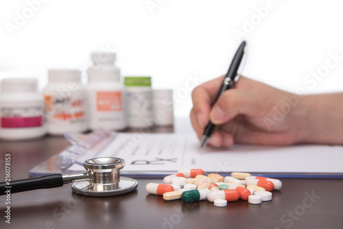 Male doctor hands writing rx prescription.