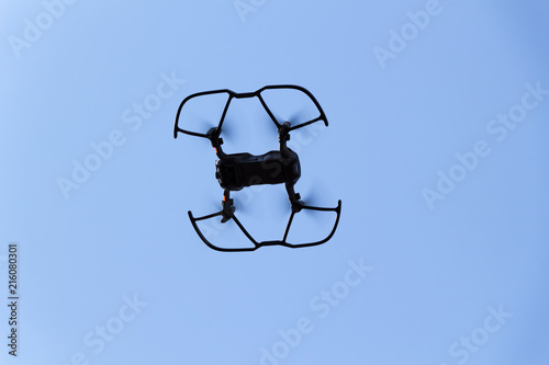 The black quadrupter flies against the blue sky. photo