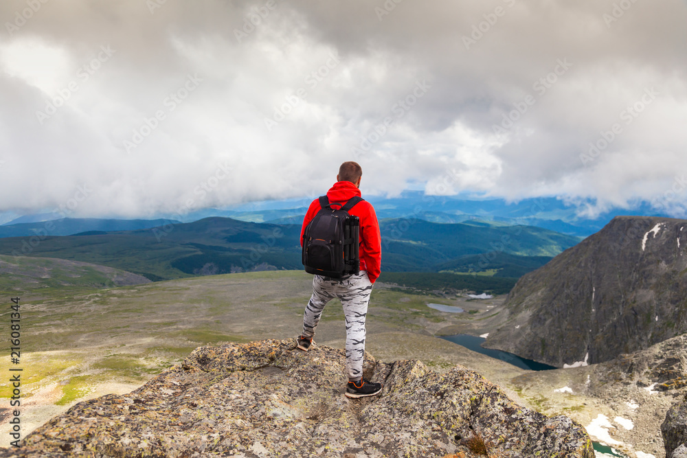 Man hiker enjoy the view at sunset mountain peak cliff.Photographer traveler on  high mountaint  Stylish man hiking. Travel Lifestyle and survival concept rear view.