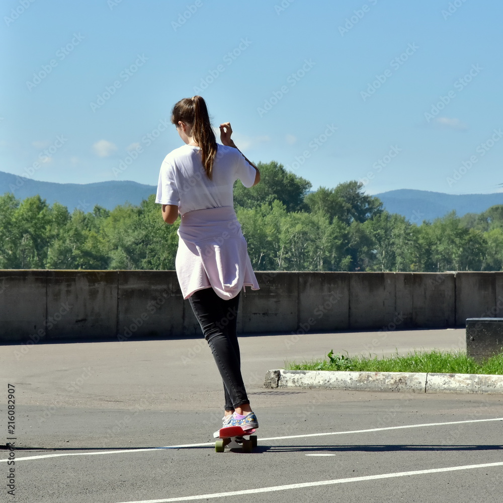 August 1, 2018. Krasnoyarsk. Russia. A young teenage girl is rolling on a seattle card and communicating on a smartphone. August 1, 2018. Krasnoyarsk. Russia. A young teenage girl is rolling on a seattle card and communicating on a smartphone.