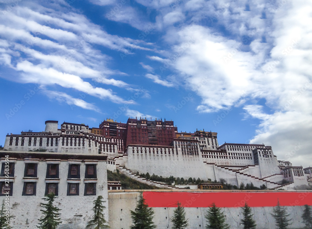 Potala Palace in Lhasa day view from town square with blue sky background, Tibet Autonomous Region. Former Dalai Lama residence, now is a museum and World Heritage Site.