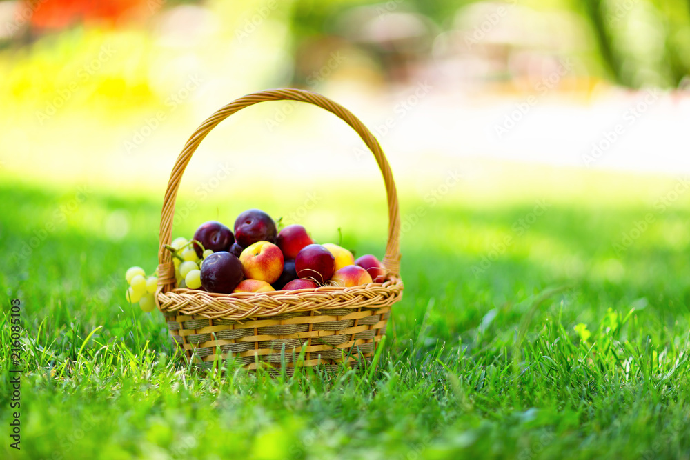 Closeup wicker basket full of ripe fruits at green grass with free space backround. Closeup wicker basket full of ripe fruits at green grass with free space backround.
