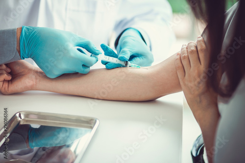 Close up Hand of nurse, doctor or Medical technologist in blue gloves taking blood sample from a patient in the hospital.