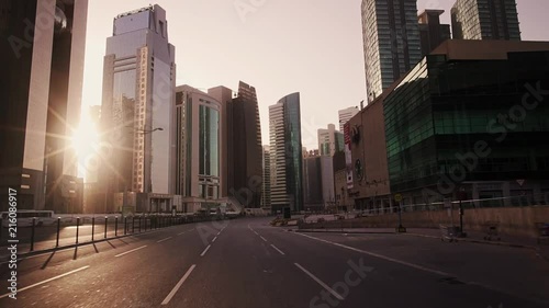 Early morning smooth drive through center of West Bay in Doha, Qatar. Sunrise peaking through the towers. photo