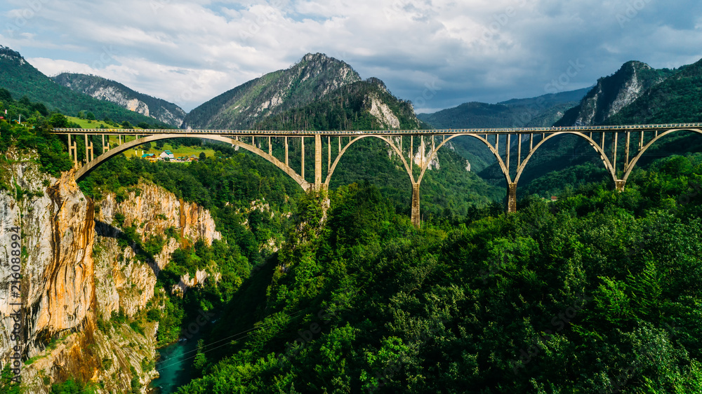Fototapeta premium Aerial View of Durdevica Tara Arc Bridge in the Mountains, One of the Highest Automobile Bridges in Europe.