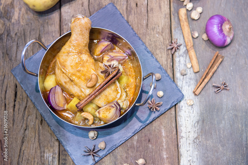 Still life food of Chicken mussaman curry in bowl on wooden background with Thai herb. photo