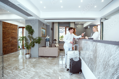 couple near reception desk in hotel
