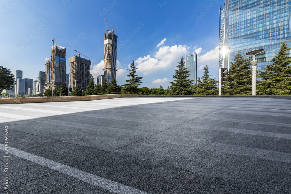 Panoramic skyline and modern business office buildings with empty road,empty concrete square floor Panoramic skyline and modern business office buildings with empty road,empty concrete square floor