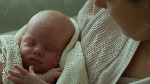 Newborn baby sleeping peacefully on the mothers hands