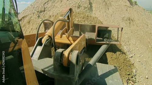 Front end bulldozer loads rocks in the truck