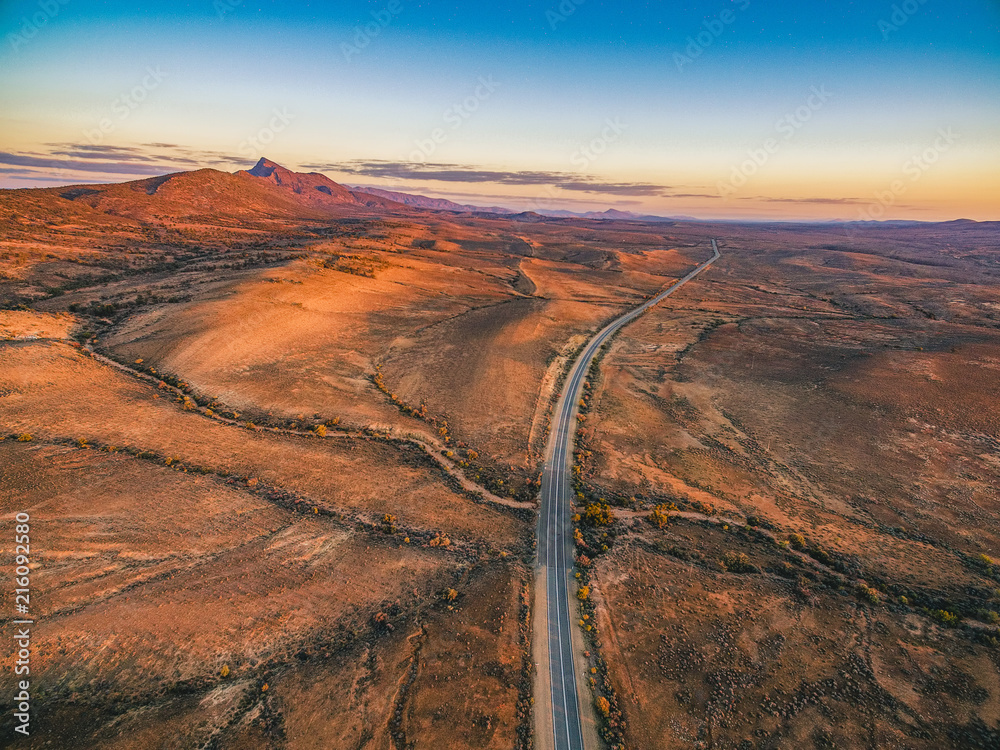 The Outback Highway passing through Flinders Ranges at dusk - aerial view