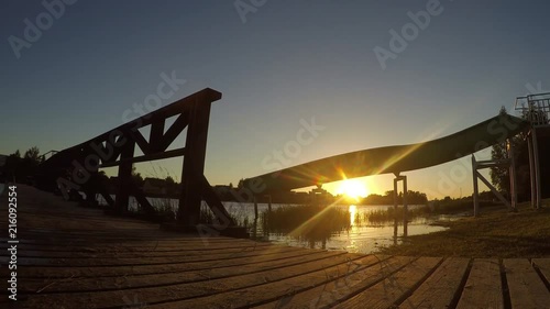 Sunshine over the river and wooden bridge. Timelapse photo