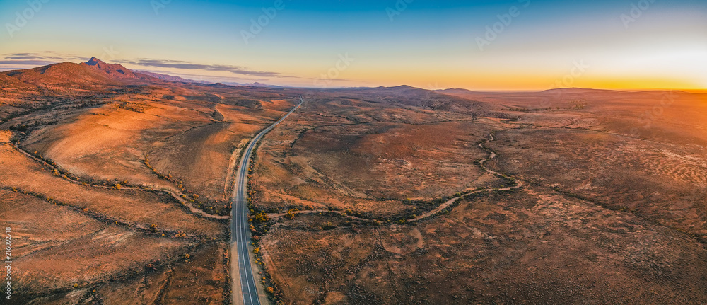 The Outback Highway passing through Flinders Ranges at dusk - aerial panorama - obrazy, fototapety, plakaty 