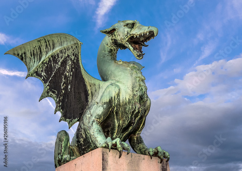 Ljubljana, Slovenia - May 20, 2018: Sculpture of dragon on Dragon bridge and beautiful dramatic sky in Ljubljana, Slovenia
