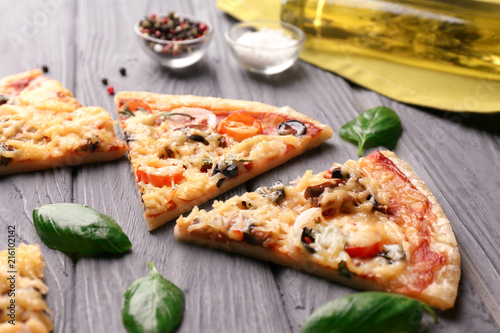 Slices of tasty pizza on wooden background