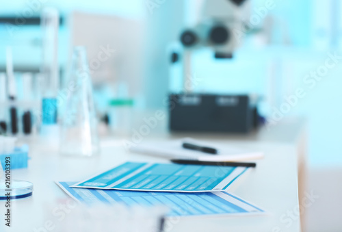 Sheets of paper with test results on table in laboratory