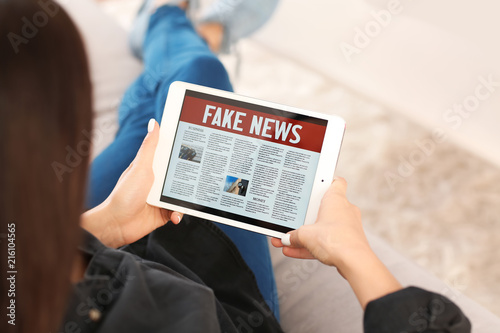 Young woman reading news on...