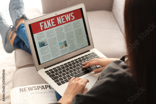 Young woman reading news on...