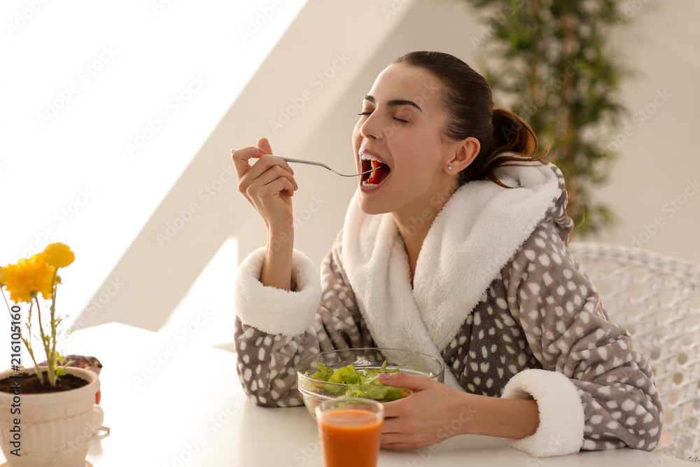 Young woman eating fresh salad at home. Healthy food concept Young woman eating fresh salad at home. Healthy food concept