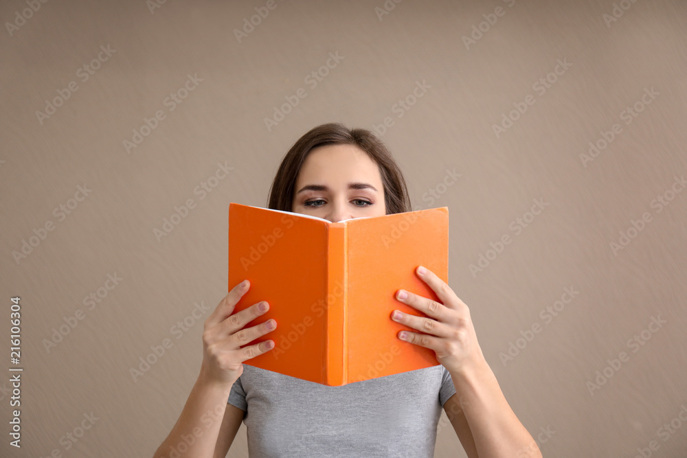 Young woman with book on color background Young woman with book on color background