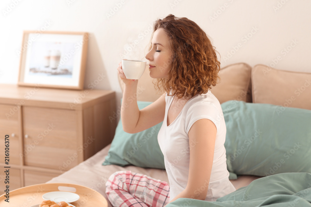 Beautiful woman drinking hot coffee in morning at home
