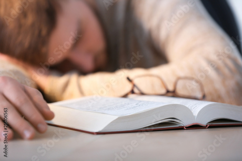 Tired young man sleeping at...