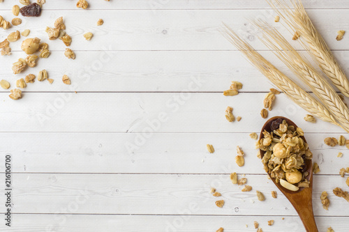 Dry Breakfast of oat flakes, granules and nuts. Muesli on a light table in a wooden spoon and ears. Copy space