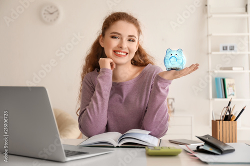 Young woman holding piggy b...