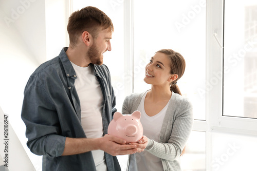 Happy couple holding piggy ...