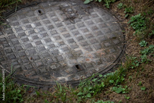 alter gullideckel in einer Wiese photo