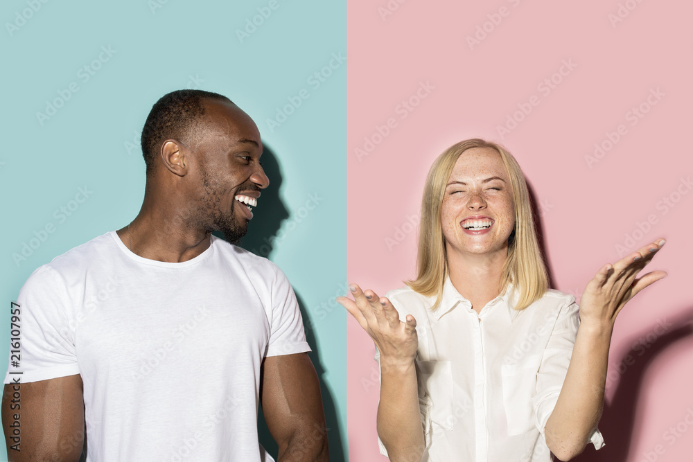 Fototapeta premium happy afro man and woman. Dynamic image of caucasian female and afro male model on pink studio.