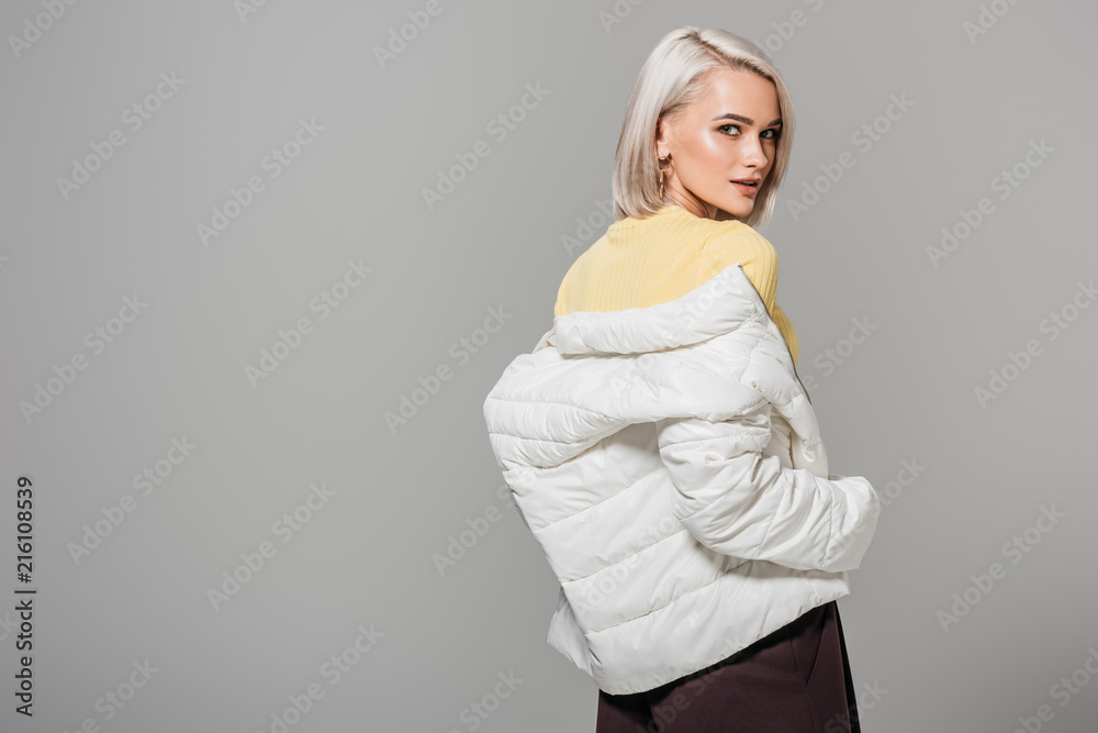 attractive young woman in stylish outfit posing isolated on grey background