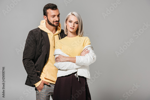 stylish couple of models posing isolated on grey background