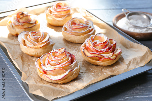 Tasty rose shaped apple pastry on baking tray