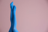Legs of beautiful young woman in bright tights on color background