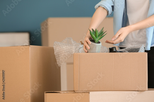 Woman packing carton box in...