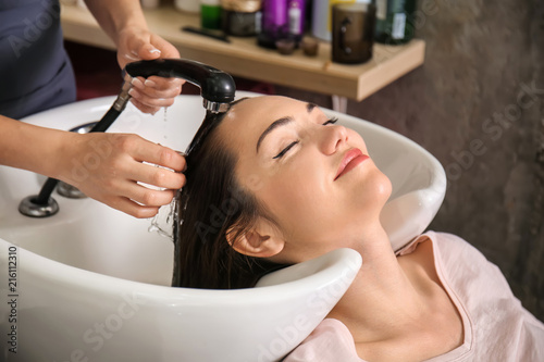 Young woman during washing of hair in beauty salon