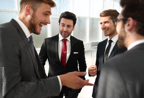 Manager and employees of the company talking standing in the office