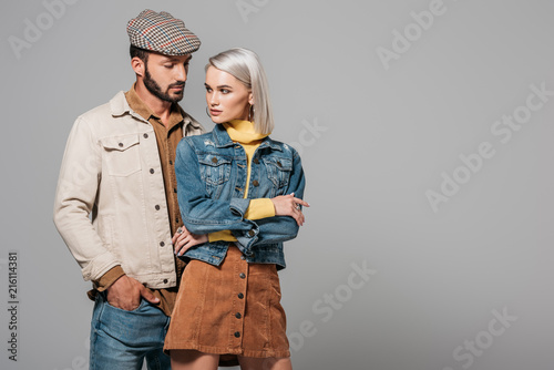 elegant stylish couple posing in autumn outfit, isolated on grey photo