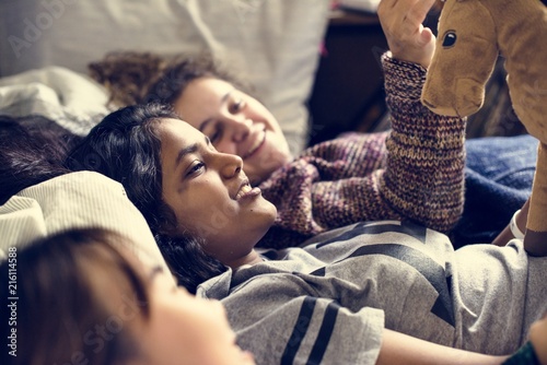 Φωτογραφία Teenage girls using smartphones on a bed internet in slumber party