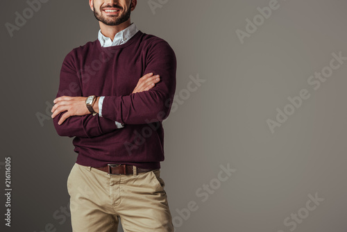 cropped view of man posing in burgundy sweater with crossed arms, isolated on grey