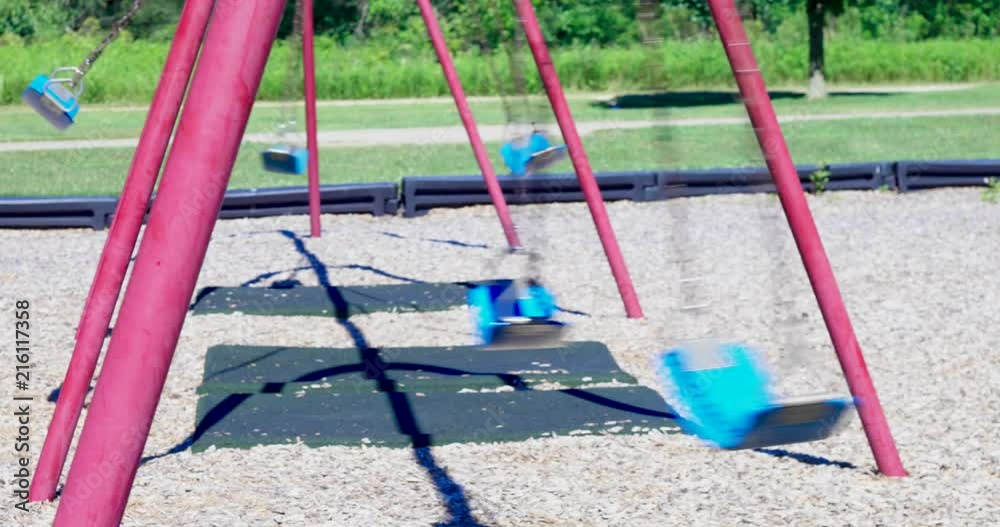 Empty swings in motion on a playground. Real Time Empty swings in motion on a playground. Real Time