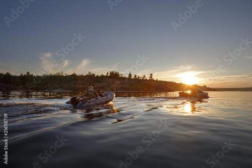 Motor boats at sunset floating on the forest lake © Maksim