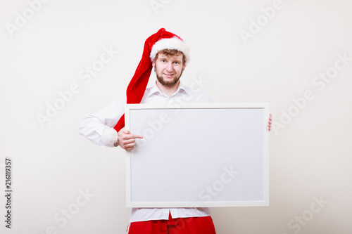 Man in santa hat with blank banner. Copy space.