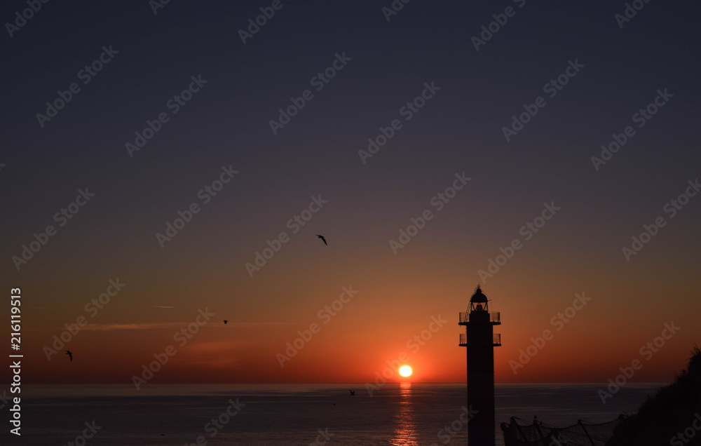 Silhouete of a lighthouse at sunrise II.