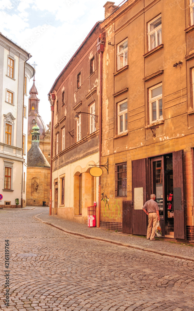 Old man is near building door, street life, Poland
