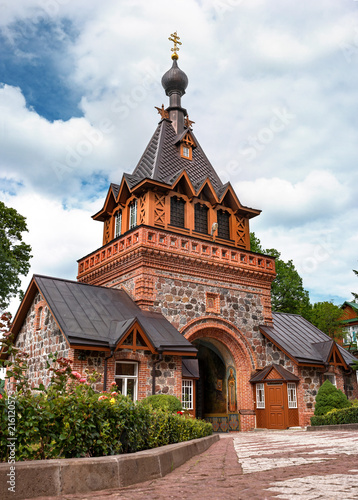 Holy gates with the belfry. The Puhtitsa Dormition convent of the Russian Orthodox Church. The gates are made of red brick and painted with icons inside. Kuremae, Estonia. Baltic country photo