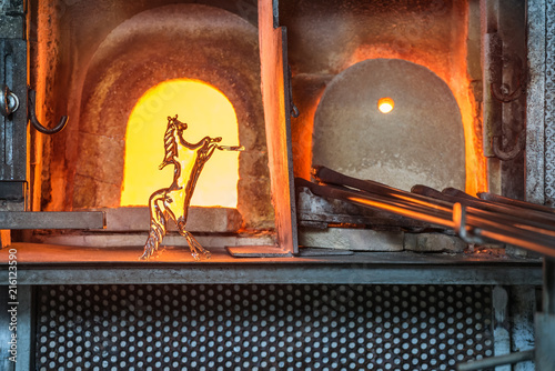 Italy, Venice, glass horse and Murano factory special glass-blowing tools: red-hot furnace with fire to make the glass malleable, and iron rods (pontello). photo