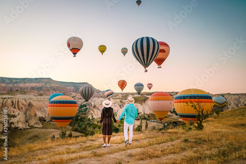 happy young couple during sunrise watching the hot air balloons of Kapadokya Cap Fototapeta