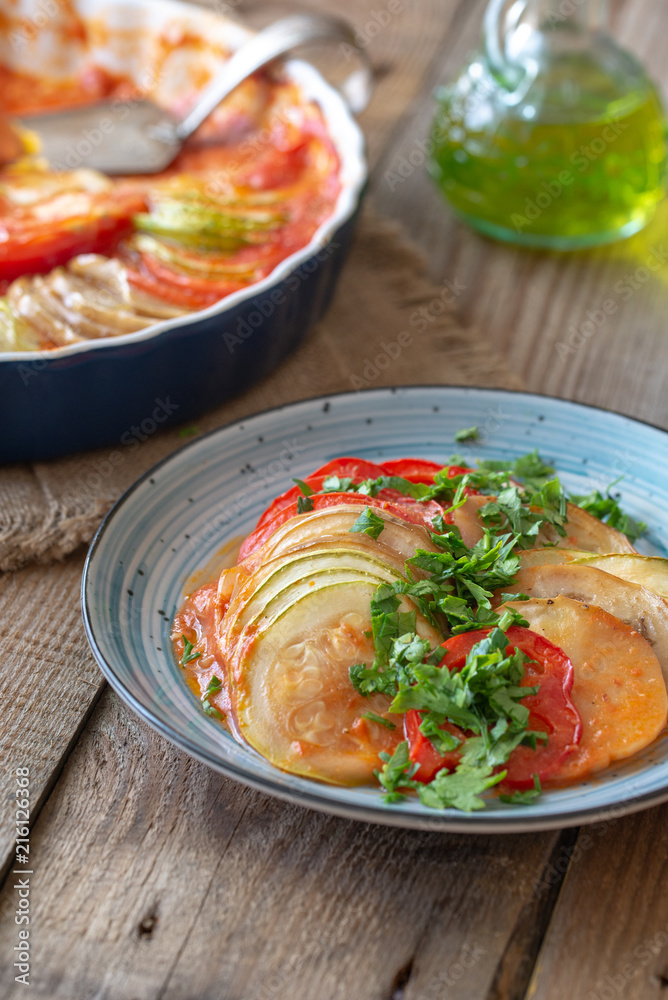 Dish of ratatouille on the wooden table Dish of ratatouille on the wooden table